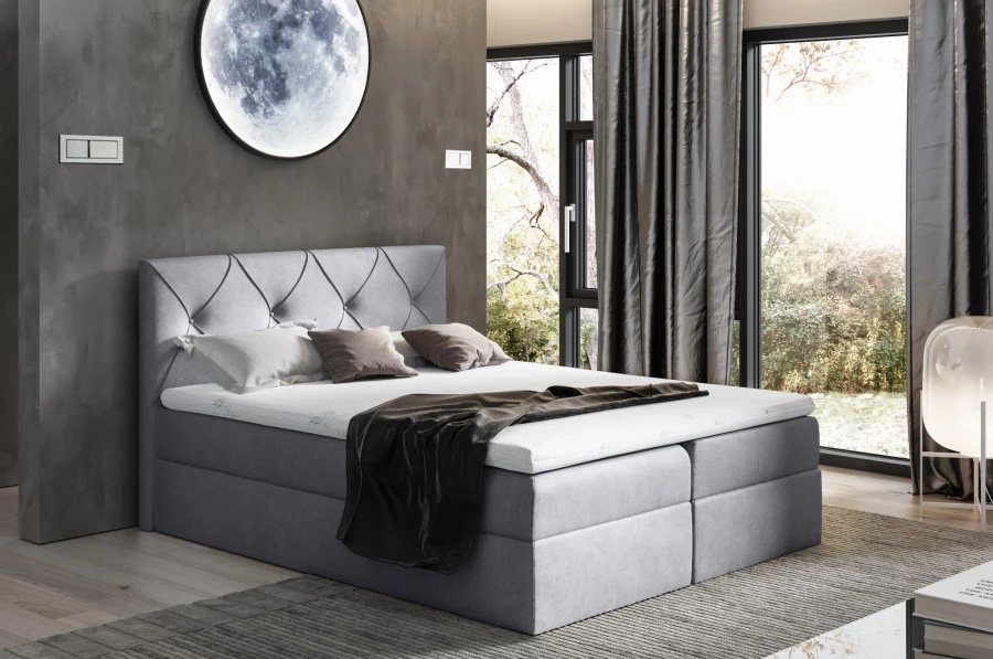 Graues Boxspringbett mit Rautenheftung im Schlafzimmer.