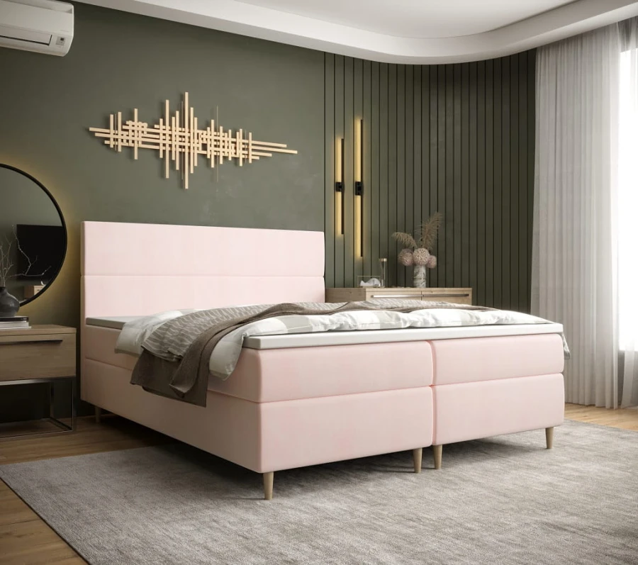 Rosa gepolstertes Boxspringbett in einem modernen Schlafzimmer.