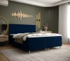 Modernes Boxspringbett in Dunkelblau mit gepolstertem Kopfteil für maximalen Komfort.