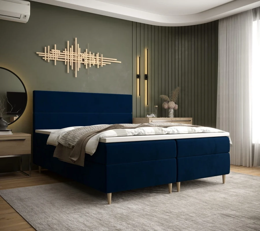Modernes Boxspringbett in Dunkelblau mit gepolstertem Kopfteil für maximalen Komfort.