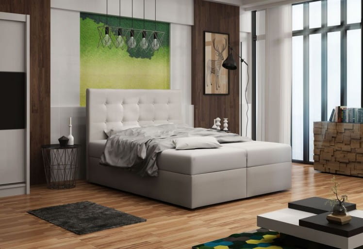 Modernes Boxspringbett in Weiß in einem stilvollen Schlafzimmer mit Holzfußboden.