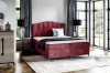 Luxuriöses Boxspringbett in Rot mit gestepptem Kopfteil im modernen Schlafzimmer.
