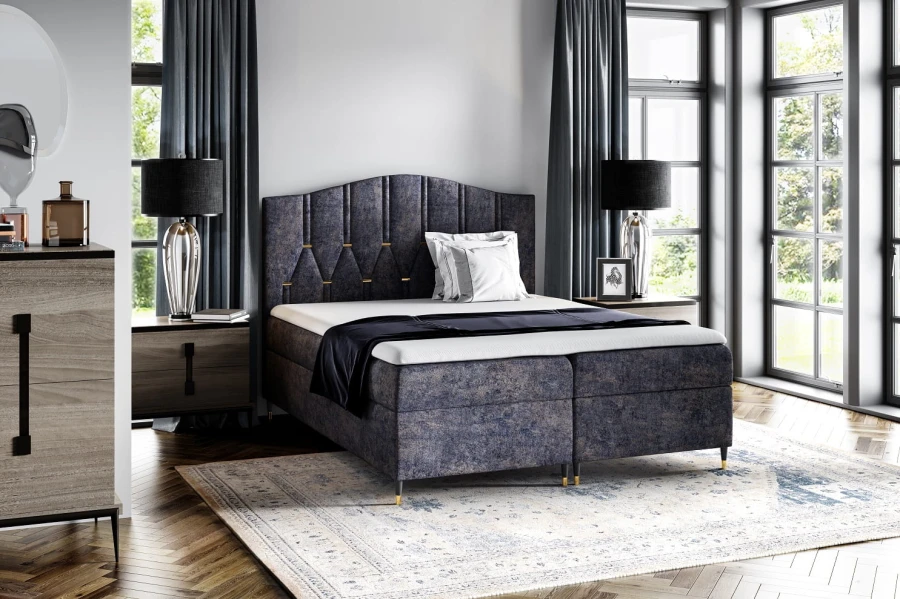 Elegantes blaues Boxspringbett mit Samtbezug und hohen Füßen im Schlafzimmer.