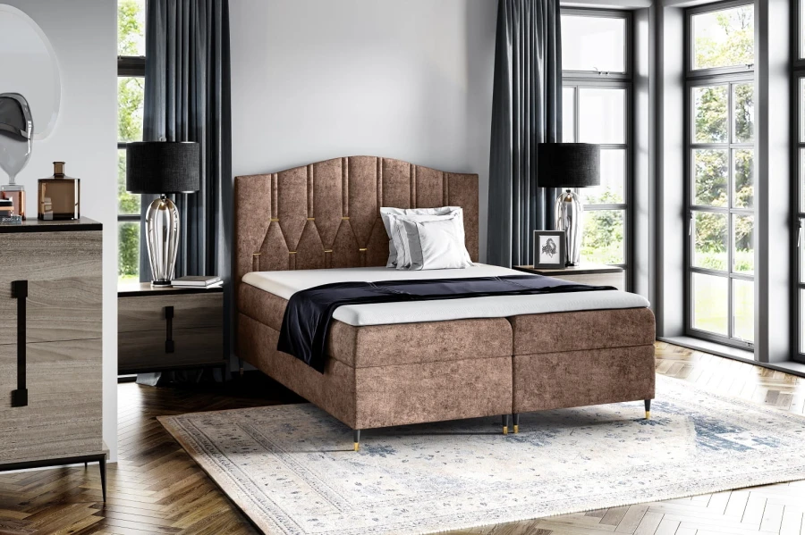 Braunes Boxspringbett mit strukturiertem Stoffbezug im gemütlichen Schlafzimmer.
