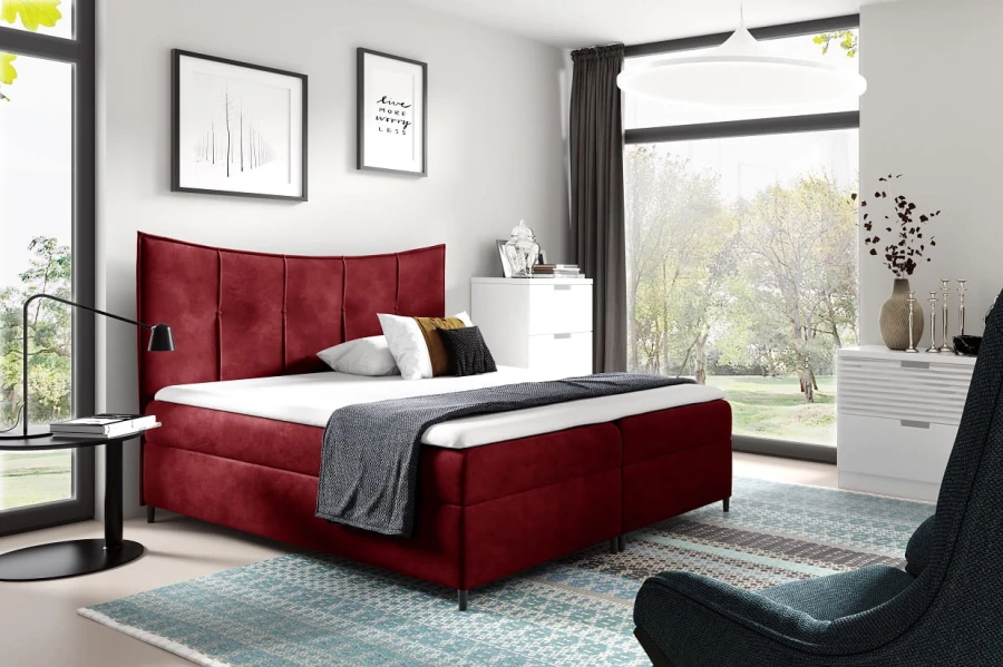 Elegantes Boxspringbett in Dunkelrot im modernen Schlafzimmer mit hellem Teppich und Dekoration.