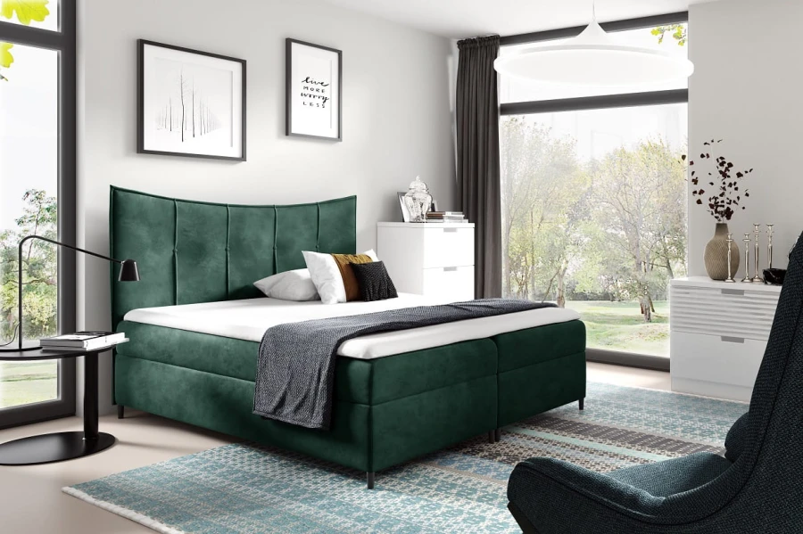 Dunkelgrünes Boxspringbett in stilvollem Schlafzimmer mit Aussicht ins Grüne.