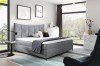 Graues Boxspringbett in hellem, modernem Schlafzimmer-Ambiente mit Dekoration.