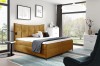 Senfgelbes Boxspringbett als Farbakzent in modern eingerichtetem Schlafzimmer.