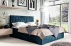 Blaues Boxspringbett mit modernem geometrischem Kopfteil im hellen Schlafzimmer