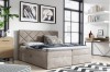 Modernes Boxspringbett in Beige mit gestepptem Kopfteil in einem hellen Schlafzimmer.