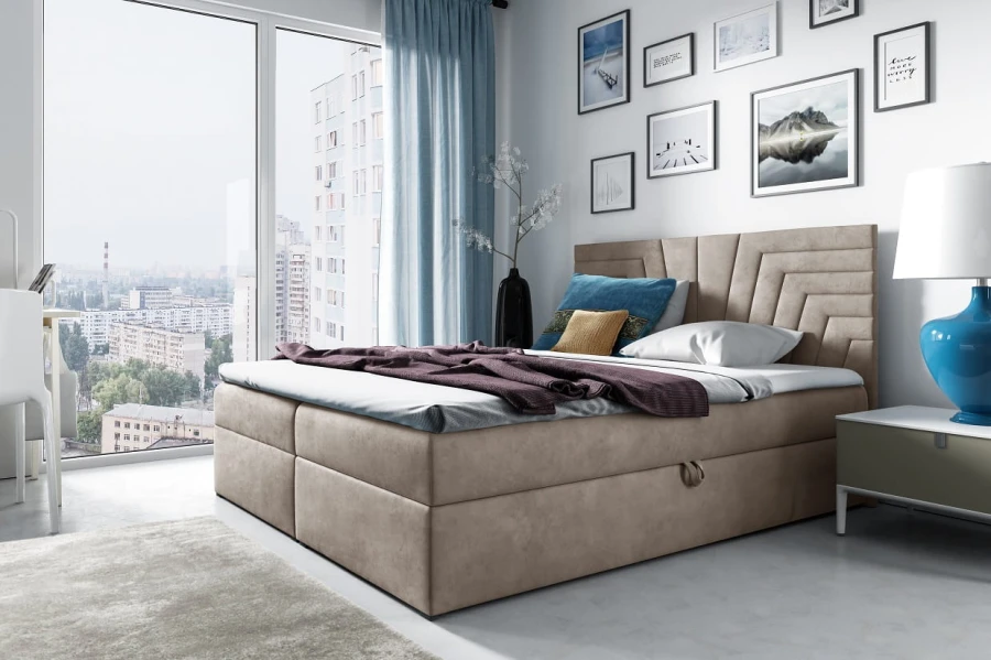Beiges Boxspringbett in modernem Schlafzimmer mit Ausblick und hellen Möbeln