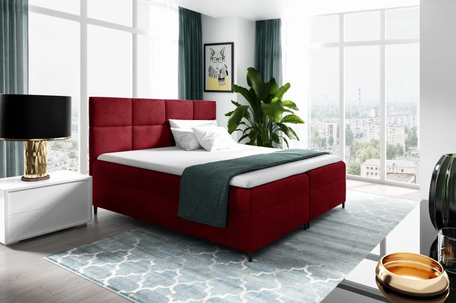 Elegantes rotes Boxspringbett als Highlight in einem hellen Schlafzimmer.