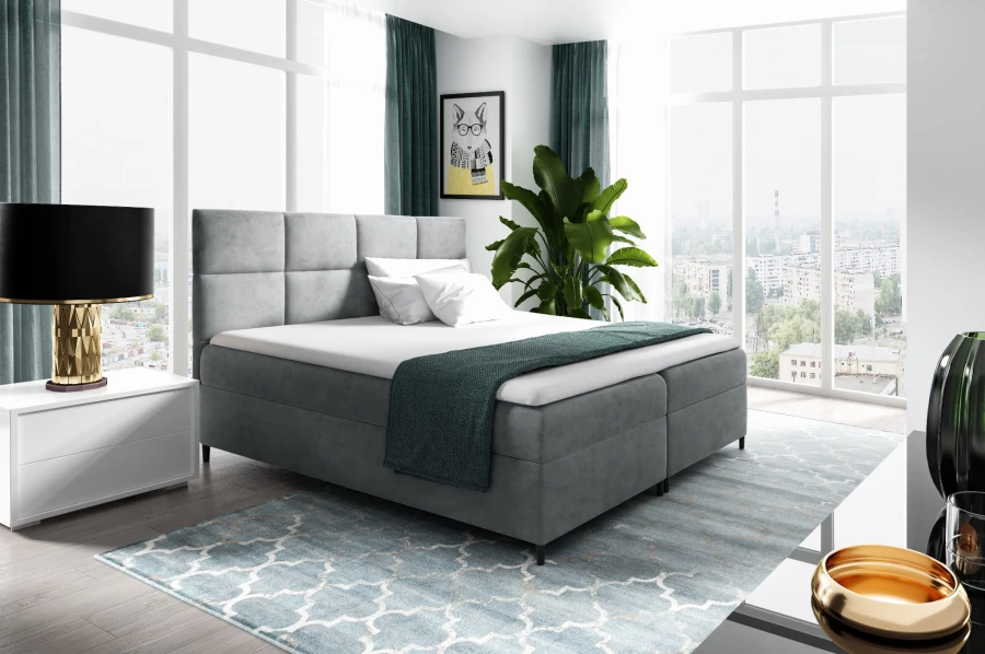 Elegantes graues Boxspringbett mit Samtbezug und quadratisch gestepptem Kopfteil.