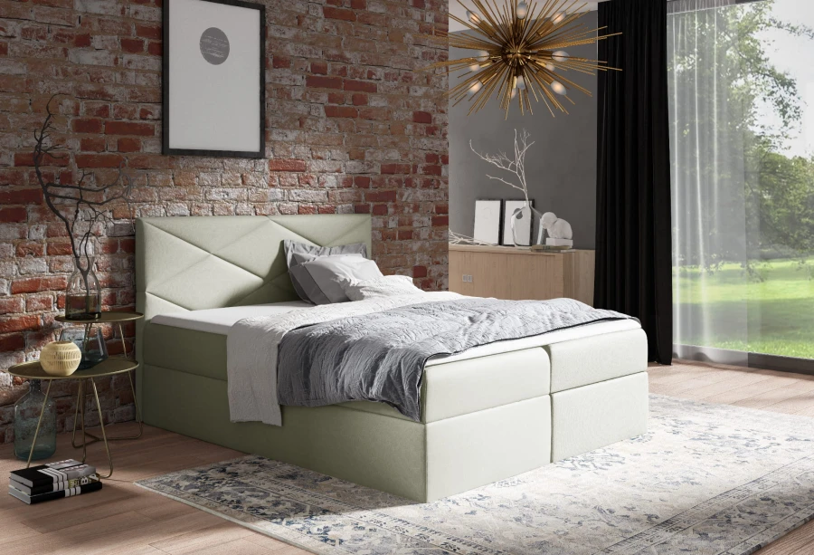 Beiges Boxspringbett für erholsamen Schlaf in gemütlichem Ambiente mit Ziegelwand.
