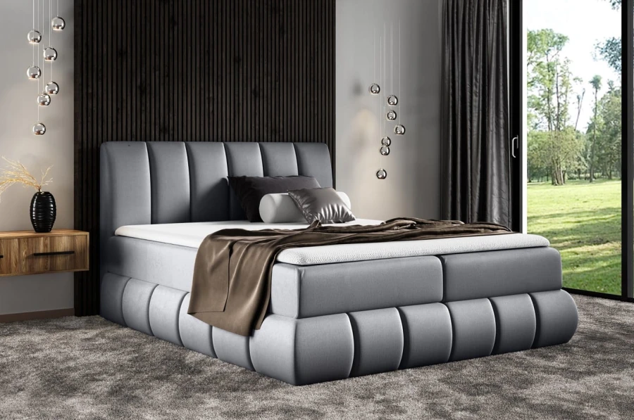 Stilvolles graues Boxspringbett mit hohem Kopfteil und weicher Polsterung im Schlafzimmer.