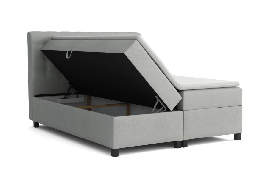 Graues Boxspringbett mit offenem Bettkasten für viel Stauraum.