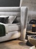 Nahaufnahme eines grauen Polsterbett-Kopfteils in modernem Schlafzimmer-Design.