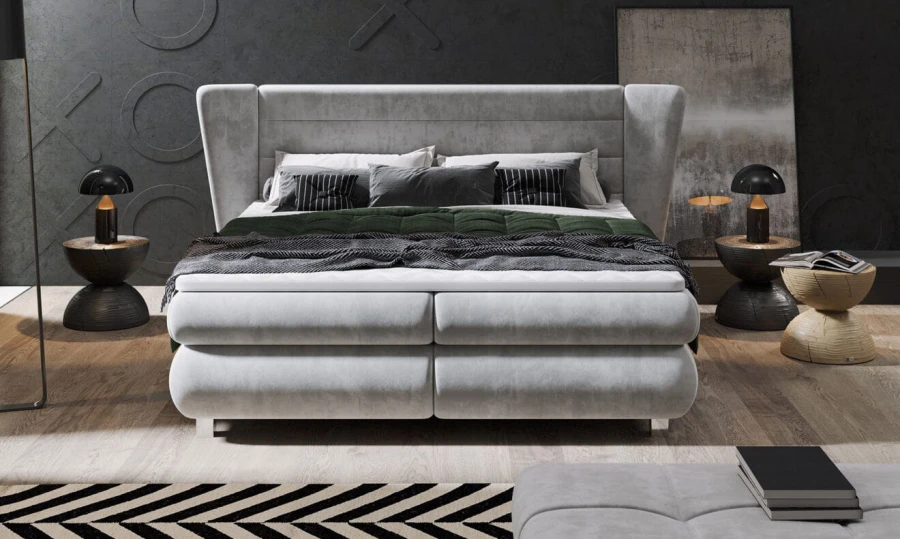 Frontansicht eines luxuriösen grauen Boxspringbetts mit hohem Kopfteil in modernem Interieur.