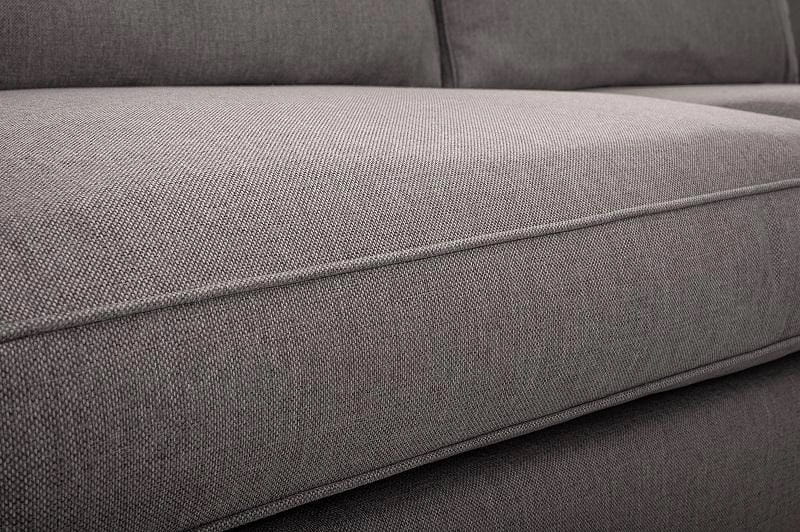 Detailansicht der grauen Webstoff-Struktur eines modernen Polstersofas.