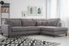 Modernes graues Ecksofa in einem hellen Wohnzimmer mit geometrischem Teppich.