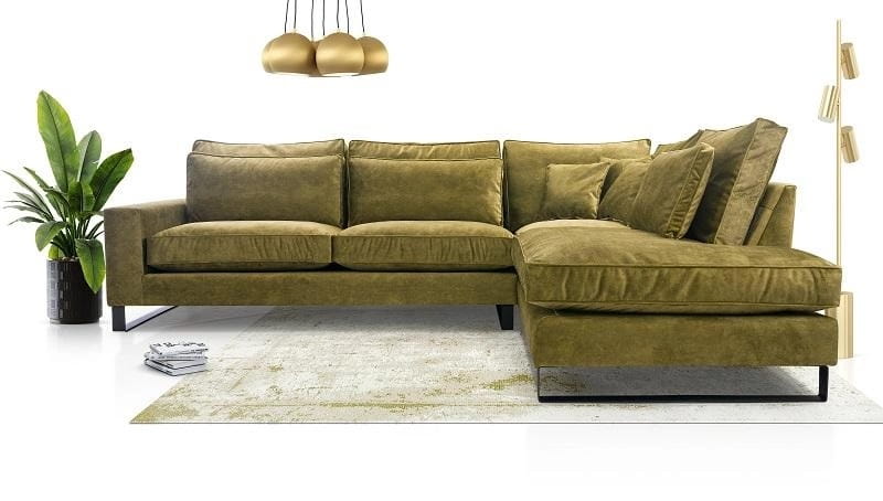 Olivgrünes L-Sofa mit Samtbezug in einem modern eingerichteten Zimmer mit goldenen Wohnaccessoires.