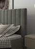 Nahaufnahme des gepolsterten Kopfteils in Anthrazit neben einem modernen Nachttisch im Schlafzimmer.