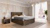 Modernes Schlafzimmer mit braunem Boxspringbett, Design-Lampe und Fensterfront.