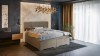 Stilvolles beiges Boxspringbett mit hoher Matratze und Kopfteil in einem modernen Schlafzimmer-Ambiente.