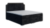 Stilvolles schwarzes Boxspringbett mit goldenen Nieten am Kopfteil und Bettkasten-Funktion.