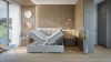 Beiges Boxspringbett mit Stauraumfunktion durch hochklappbare Matratzen in modernem Design.