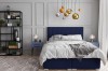 Dunkelblaues Boxspringbett in modernem Schlafzimmer-Design mit eleganten Pendelleuchten.