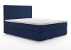 Dunkelblaues Boxspringbett mit gepolstertem Kopfteil und weißer Matratze.