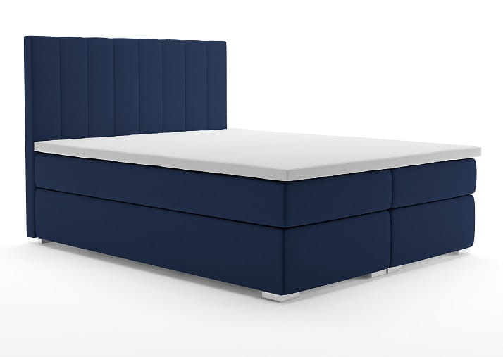 Dunkelblaues Boxspringbett mit gepolstertem Kopfteil und weißer Matratze.