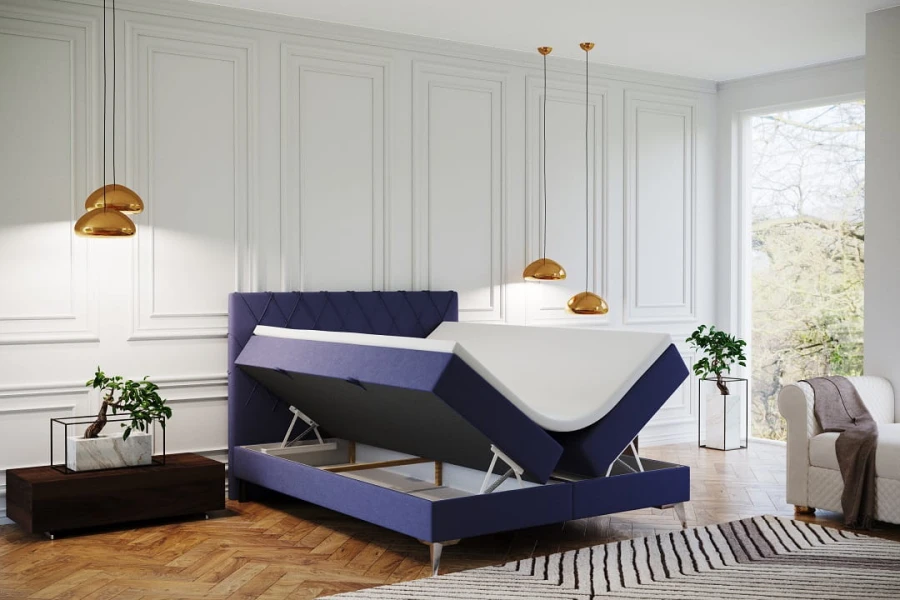Blaues Boxspringbett mit aufgeklapptem Bettkasten für extra Stauraum im modernen Schlafzimmer.