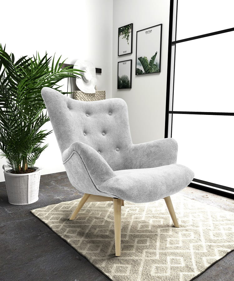 Hellgrauer Polstersessel in modernem Wohnzimmer mit Teppich, Zimmerpflanze und Wandbildern.
