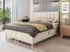 Modernes beige Boxspringbett mit gestepptem Kopfteil und Bettkasten im hellen Schlafzimmer.