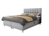 Elegantes graues Boxspringbett mit Knopfsteppung am Kopfteil, freigestellt auf weißem Hintergrund.