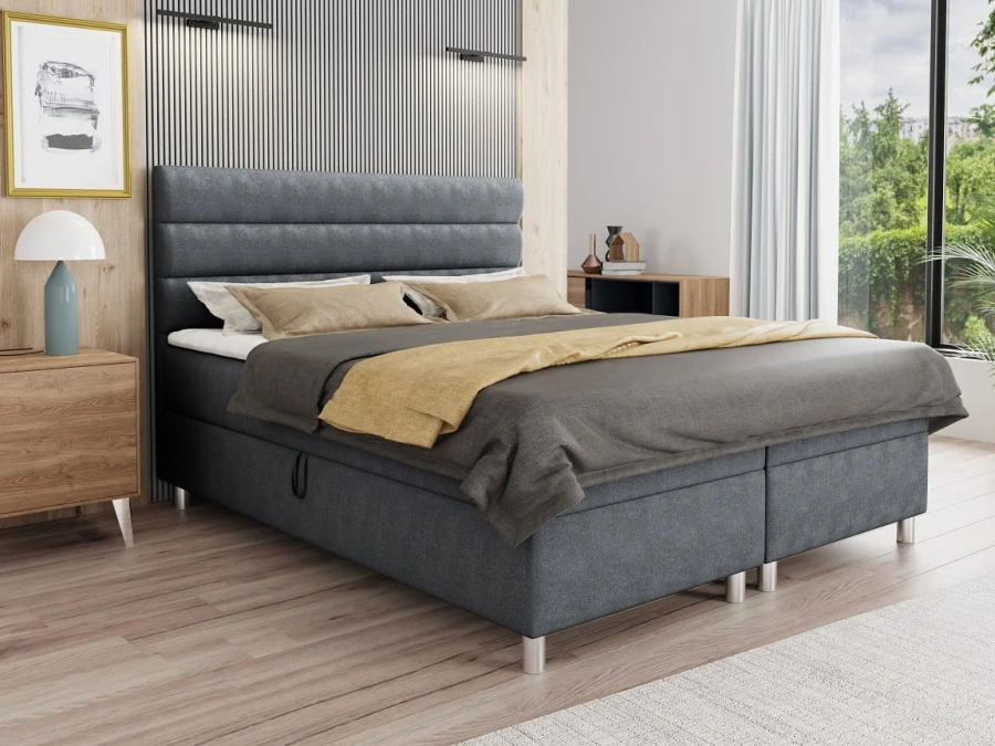 Dunkelgraues Boxspringbett mit horizontal gestepptem Kopfteil in stilvollem Schlafzimmer.