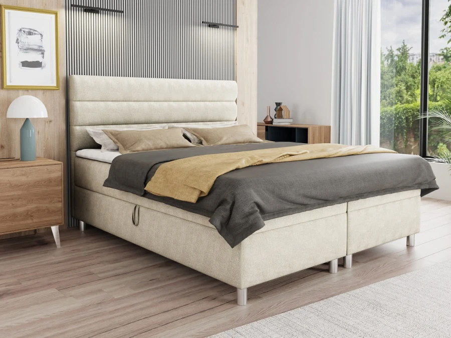 Beiges Boxspringbett im modernen Schlafzimmer-Design mit Stoffbezug.