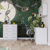Eingerichtetes Kinderzimmer mit weißem Schreibtisch, Kommode und Dschungeltapete.