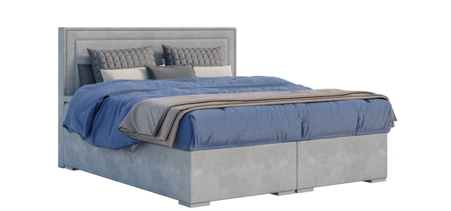 Freistehendes graues Boxspringbett mit gestepptem Kopfteil und blauer Bettdecke auf weißem Grund.