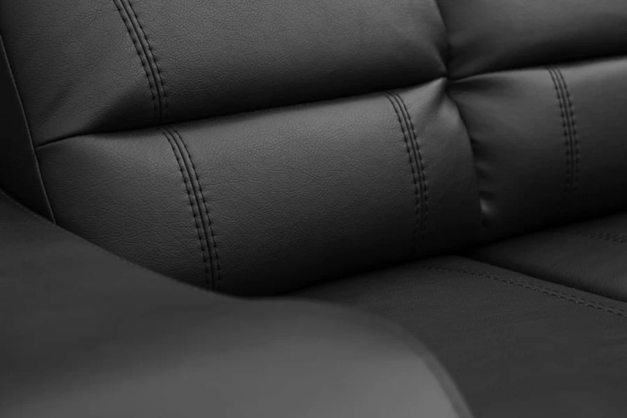 Gepolsterte Segmente der Rückenlehne eines schwarzen Sofas mit präziser Steppung.