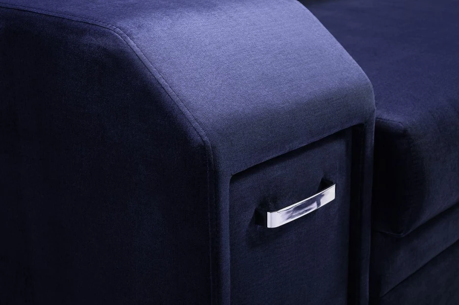 Nahaufnahme der blauen Stoffoberfläche und des Griffs an der Couch-Armlehne.