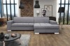 Modernes hellgraues Ecksofa in L-Form in einem stilvoll eingerichteten Wohnzimmer.