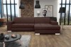Dunkelbraunes Ecksofa mit modernem Design vor einer rustikalen Ziegelsteinwand.