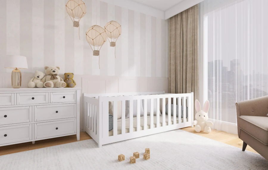 Elegantes weißes Gitterbett für Babys aus Massivholz in einem hellen Kinderzimmer mit Kommode.
