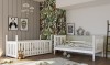 Zwei weiße Kinderbetten in einem modern eingerichteten Kinderzimmer mit tropischer Motivtapete.