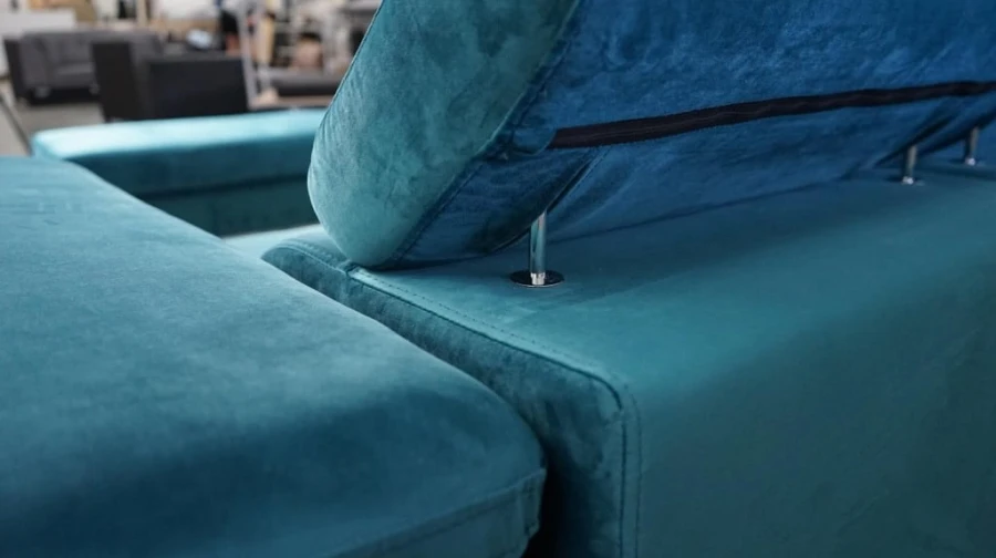 Detailansicht der verstellbaren Kopfstützen-Halterung am petrolfarbenen Sofa.