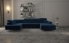 Modernes dunkelblaues U-Sofa in stilvollem Wohnzimmer-Ambiente mit Teppich.