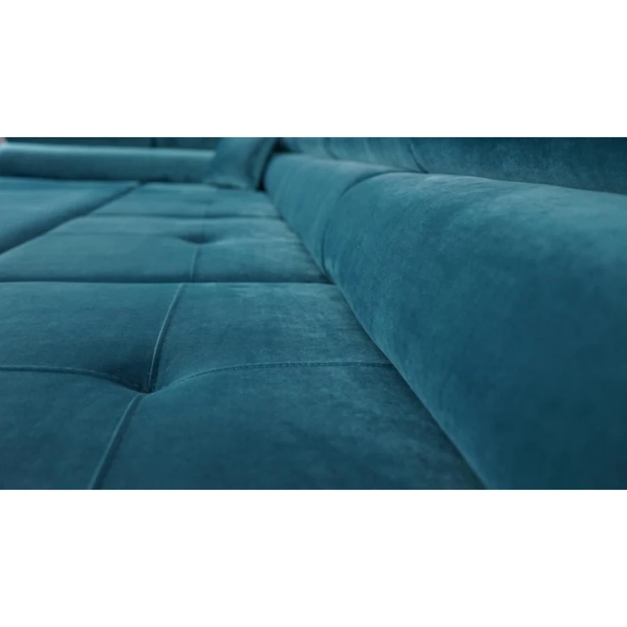 Nahaufnahme der gesteppten Sitzfläche eines blauen Ecksofas aus Samt.